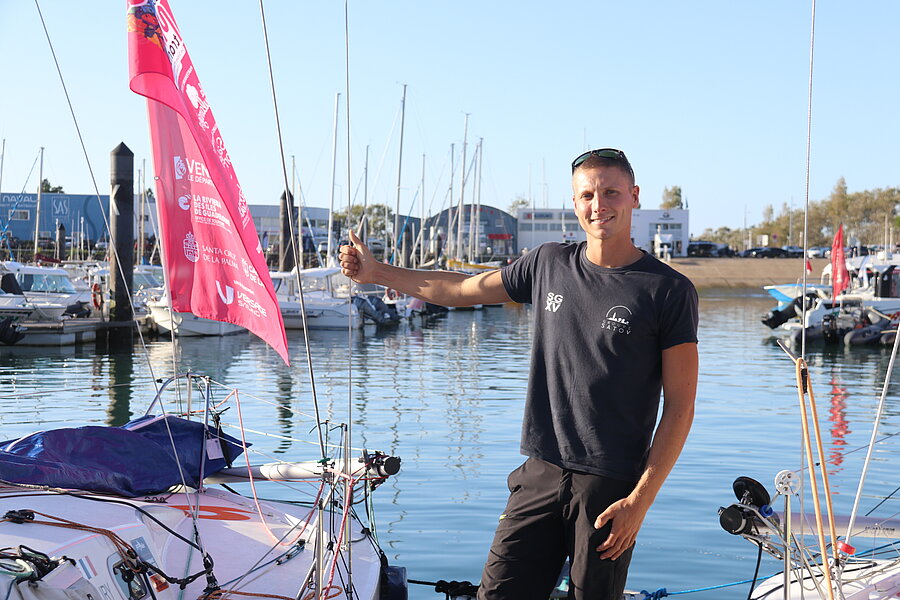 Amaury Guérin à côté de son bateau aux Sables-d'Olonne avant le grand départ de la Mini Transat 2025