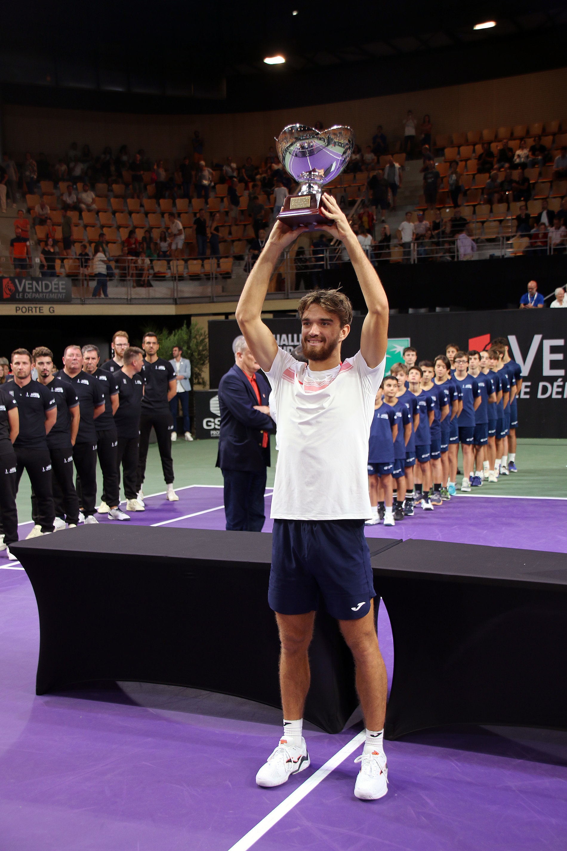 Joueur de tennis soulevant le trophée qu'il vient de remporter