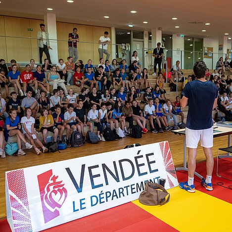 Les enfants écoutent le joueur Jules Marie lors d'une conférence.