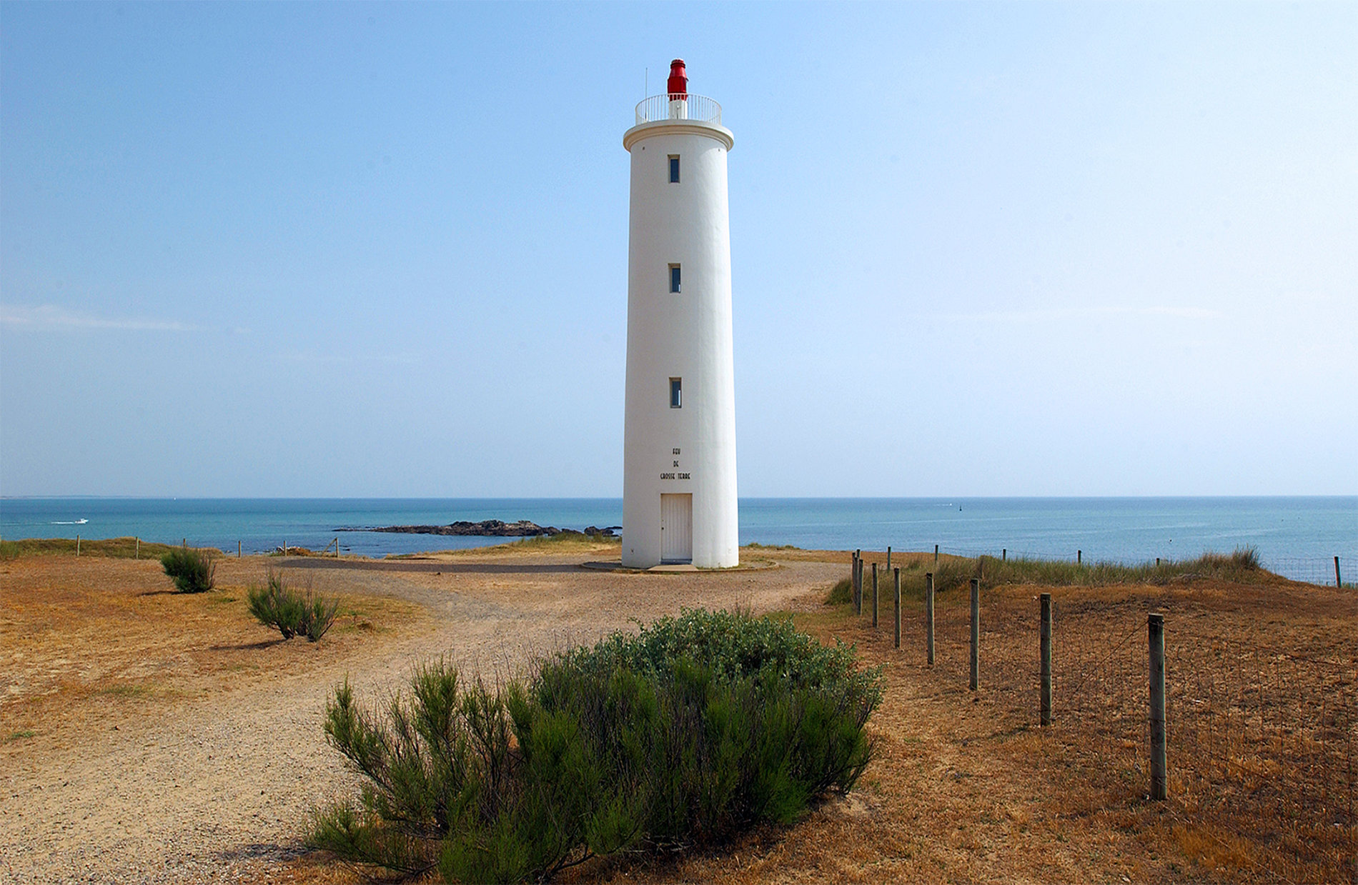 Photo du feu de Grosse Terre, blanc sur un paysage maritime bleu
