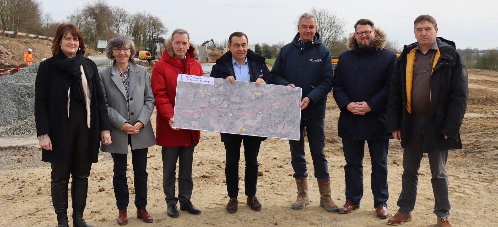 Photographie des élus départementaux Bérangère Soulard, Brigitte Hybert, Guillaume Jean et Alain Leboeuf, accompagnés du maire des Herbiers Christophe Hogard et du président du Puy du Fou Laurent Albert. Ils sont sur le chantier des travaux de la D11 en Vendée pour garantir un meilleur accès aux communes avoisinant le Puy du Fou.